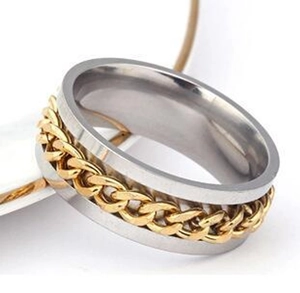 Detailed shot of a rotating stainless steel ring with a gold chain inlay on a silver band