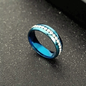 Macro shot of blue titanium steel ring with a single row of clear sparkling crystals