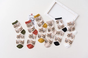 Close-up of thin mesh socks with cat patterns in various colors on white background