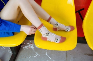 Macro detail of ultra-thin transparent socks with realistic cat head prints and red contrast
