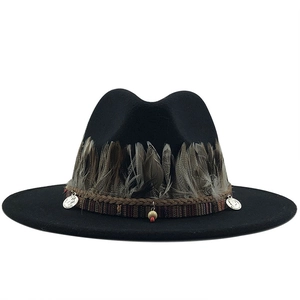 Black wool fedora with bohemian feather trim and ethnic beaded charms on white background