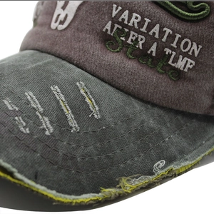 Detail of distressed baseball cap with vintage wash and contrast yellow stitching