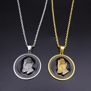 Detail of hip hop praying hand pendants with Greek fret border in gold and silver finish