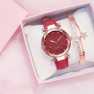 Detail of a chic women's watch with red glitter dial and star pendant bracelet set