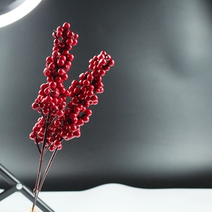 Detail of red artificial berry stems with glossy round berries for Christmas DIY crafts