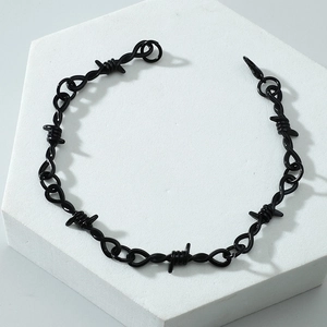 Unisex black thorn wire chain bracelet with punk aesthetic on white display stand