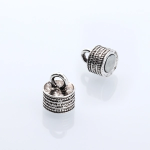 Antique silver cylindrical magnetic jewelry clasp with intricate dot texture and top loop