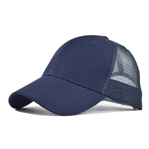 Detailed side view of navy blue cotton trucker hat with mesh back and curved visor