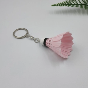 Detailed view of a pink badminton shuttlecock keychain with durable metal ring and chain