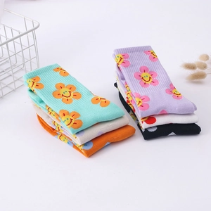 Stack of colorful cotton crew socks featuring cheerful sunflower smiley face patterns
