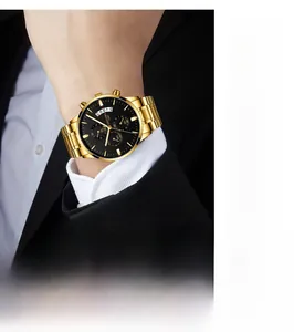 Détail d'une montre en acier doré avec cadran noir et chronographes au poignet masculin