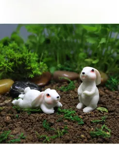 Dettaglio di coniglietti in miniatura in resina su muschio verde per decoro da giardino
