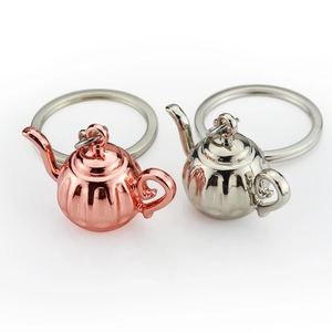 Pair of creative 3D metal teapot keychains in polished rose gold and silver finishes