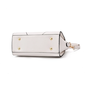 Bottom view of beige leather handbag featuring protective gold metal feet and neat stitching