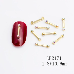 Detailed view of 10.6mm gold nail art bar charm with rhinestones on burgundy polish
