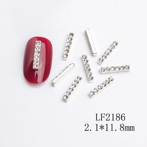 Macro shot of silver rectangular nail art rhinestones on a red nail plate display