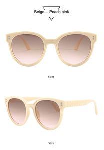 Detail view of beige round sunglasses with textured temples and peach gradient lenses