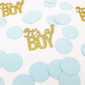 Macro shot of blue circle confetti and gold glitter It's a Boy cutouts for baby shower