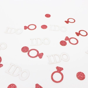 Close-up of rose gold glitter I DO and ring-shaped confetti for wedding decorations