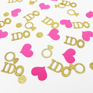 Detail of gold glitter I DO letters and rose red heart confetti for wedding party decor