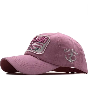 Close-up of pink cotton baseball cap with vintage marine embroidery and anchor patches