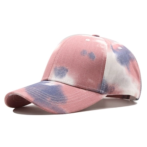 Detail of pink and blue tie-dye cotton baseball cap with curved brim and 45-degree side view