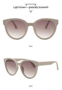 Detailed view of beige round sunglasses with light brown gradient lenses and textured temples