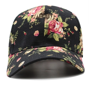 Detailed view of black baseball cap with vibrant red rose floral pattern and curved brim