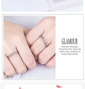 Close-up of couple's silver rings featuring a solitaire diamond and parallel band design