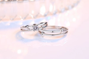 Close-up of silver couple rings with brilliant round cut stone and hollow band details