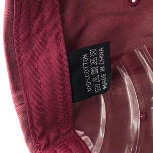 Macro shot of 100% cotton washed baseball cap interior showing sewing and care labels