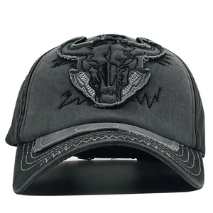 Detailed close-up of bull skull embroidery on washed dark grey vintage cotton baseball cap