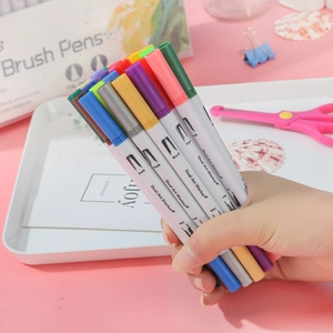 Dual art markers with brush and fine tips set on creative desk with art supplies
