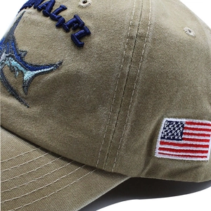 Close-up of khaki washed cotton baseball cap with marlin embroidery and US flag patch