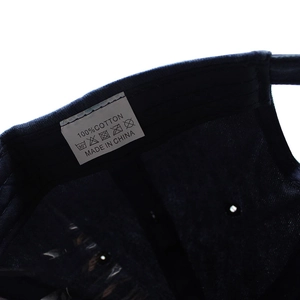 Close-up of washing label and stitching inside the navy blue cotton baseball cap
