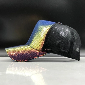 Close-up of vibrant gradient sequins and breathable black mesh on a stylish trucker cap