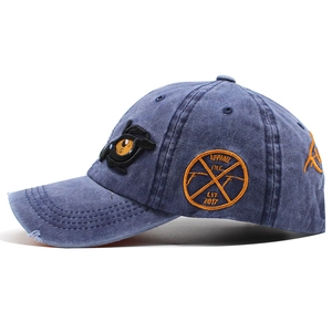 Vintage washed navy denim baseball cap with orange eye embroidery and distressed brim edge