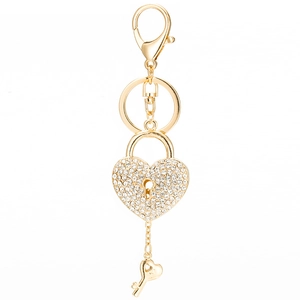 Golden heart lock keychain with sparkling rhinestones and small key pendant on white background
