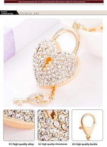 Detail showing gold heart lock keychain with sparkling rhinestones and matching key