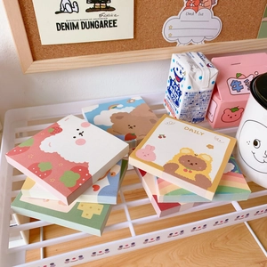 Close-up of cute cartoon bear sticky notes and memo pads stacked on a desk shelf