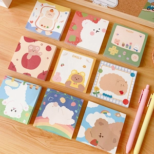Flat lay of 9 cute cartoon bear and animal memo pads on a natural wooden background