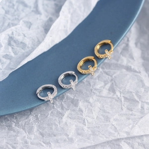 Detail of silver and gold S925 sterling silver hoop earrings with zircon crosses