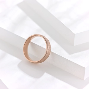 Détail macro d'une bague or rose avec surface sablée et polissage intérieur doux