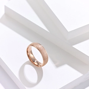 Vue macro d'une bague en or rose avec finition givrée mate et intérieur poli miroir