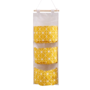 Hanging cotton linen organizer with three pockets in yellow star pattern and wooden bar