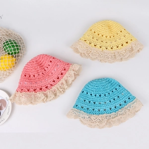 Detailed view of hand-woven straw hats with lace trim in yellow, pink and blue