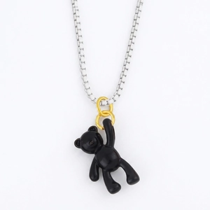 Cute black bear pendant necklace with silver box chain and gold rings on white background