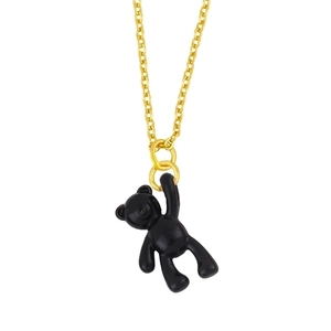 Macro detail of golden chain necklace with a 3D black enamel bear pendant for women