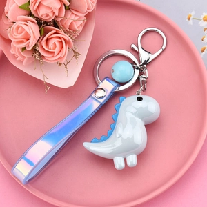 Close-up of cute blue dinosaur charm with holographic wristlet and silver lobster clasp
