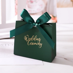 Close-up of elegant dark green wedding candy box with a large matching satin ribbon bow